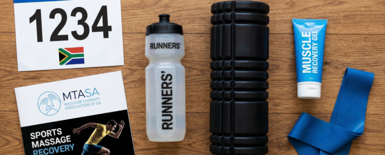A flat-lay photograph on a wooden surface showing a South African race number bib, water bottle, foam roller, muscle gel, resistance band, and an MTASA sports recovery brochure.