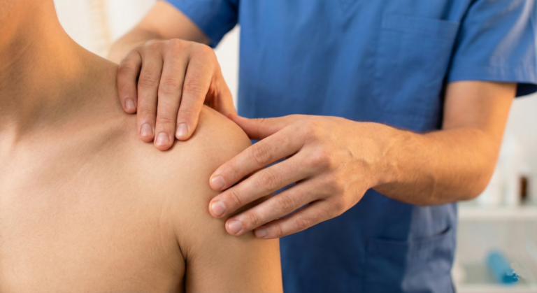 A close-up of a therapist's hands performing gentle myofascial release on a patient's shoulder to treat chronic pain and fibromyalgia.